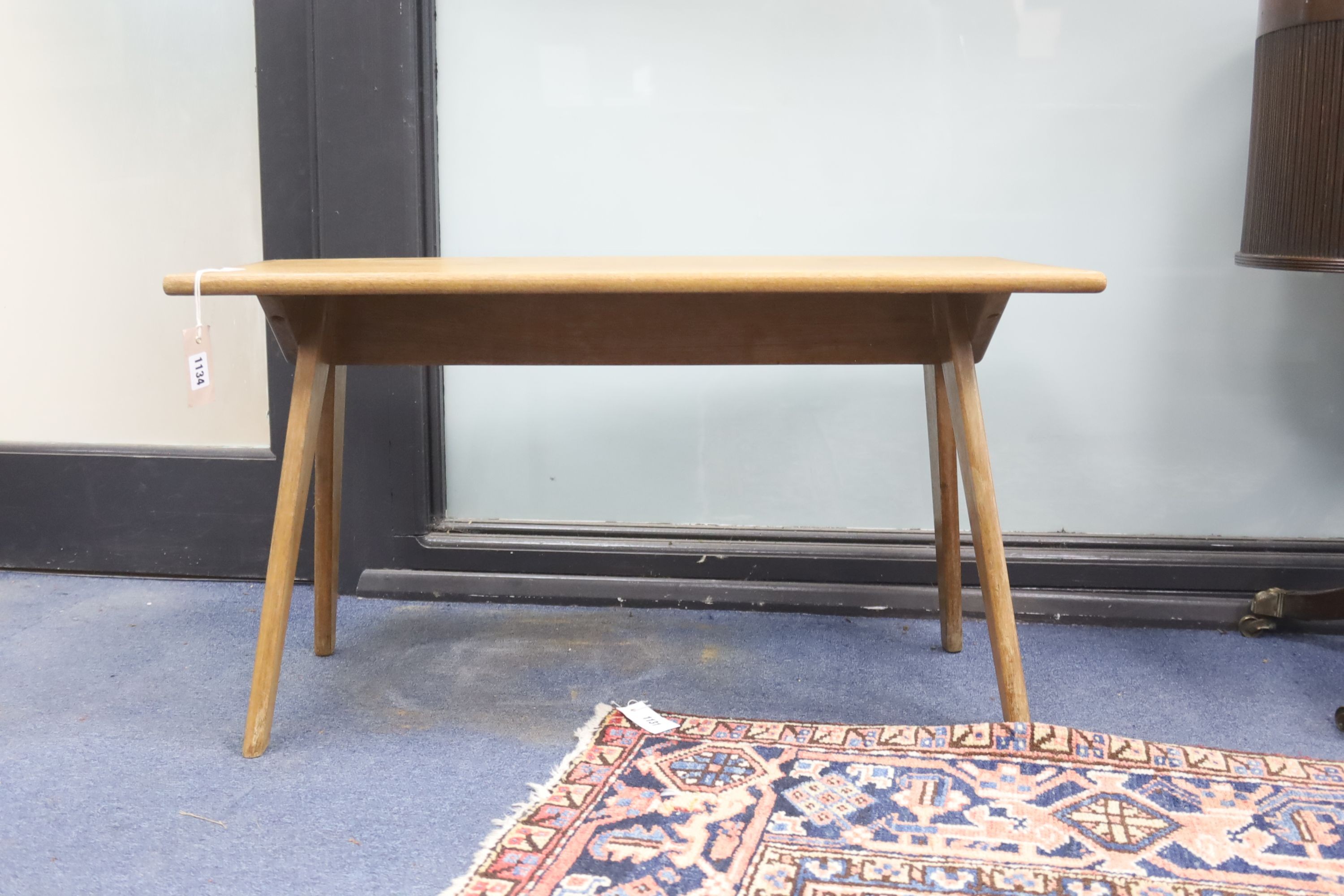 In the style of Pierre Jeanneret. A rectangular teak occasional table on compass leg, width 84cm, depth 37cm, height 46cm